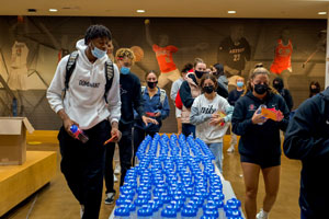 Shown here in 2021, SDSU student athletes write inspirational messages to be attached to water bottles Hill plans to give to individuals in homeless shelters