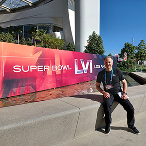 SMBA '22 Candidate Jim Wilkie sitting in front of the NFL Super Bowl LVI sign