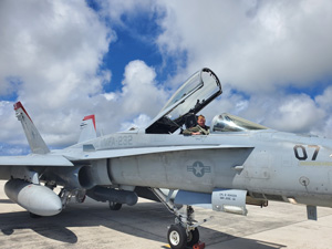 Willis sits in the cockpit of a U.S. Marine Corps  F/A-18 Hornet fighter jet