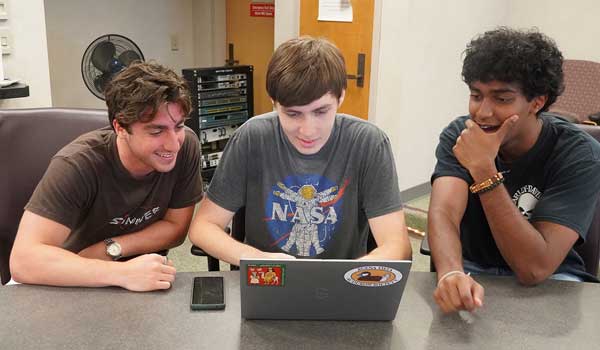 Three DiLab students work on a project
