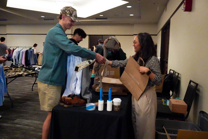 student getting their clothes bagged at check out